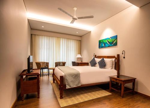 a bedroom with a bed and a table and chairs at JA Enchanted Waterfront Seychelles in Mahe