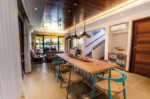 a kitchen with a wooden table and chairs at JA Enchanted Waterfront Seychelles in Mahe