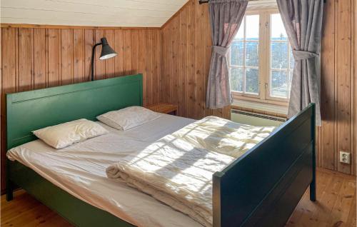 a bedroom with a bed with a green headboard and a window at Beautiful Home In yer With Wifi And 3 Bedrooms in Øyer