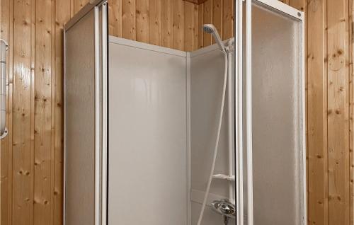 La salle de bains est pourvue d'une cabine de douche et de murs en bois. dans l'établissement 3 Bedroom Cozy Home In yer, à Øyer