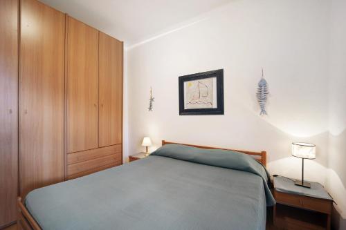 una camera con letto blu e armadio in legno di Casa Serena 12 a Bordighera