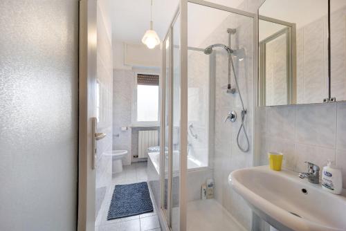 bagno bianco con doccia e lavandino di Casa Serena 12 a Bordighera