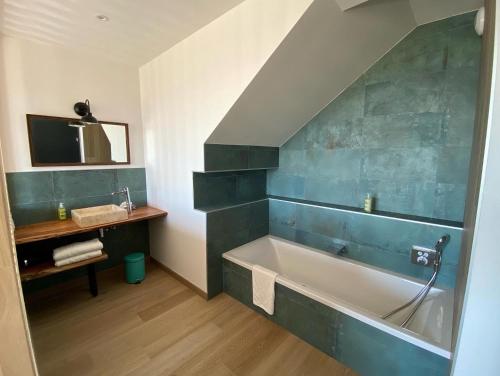 a bathroom with a bath tub and a sink at Hôtel Le Lichen De La Mer in Batz-sur-Mer