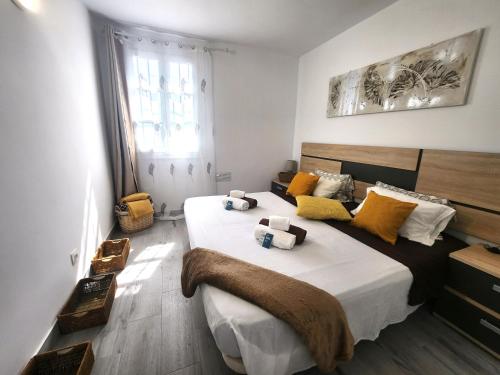 Un dormitorio con una cama grande con almohadas amarillas y blancas en CASA ALICE COCOSOL, en Costa de Antigua