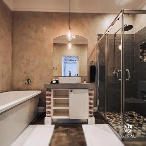 a bathroom with a tub and a sink and a shower at Pont de Val Boutique Hotel And Apartments in Barrage