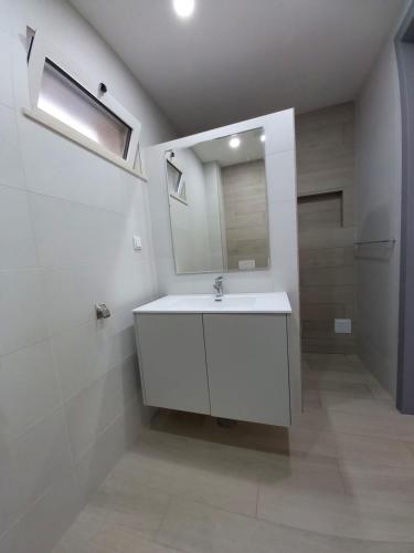 W łazience znajduje się biała umywalka i lustro. w obiekcie Villa Girassol met zwembad w mieście Alcantarilha