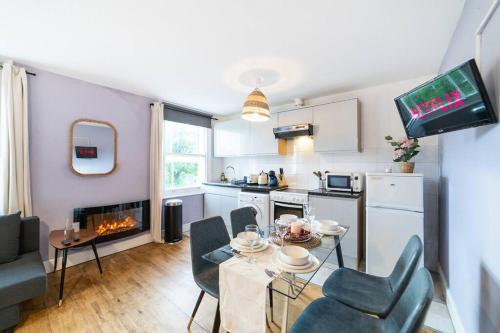uma cozinha e sala de estar com mesa e cadeiras em [Bayswater-Hyde park] London Studio Apartment em Londres