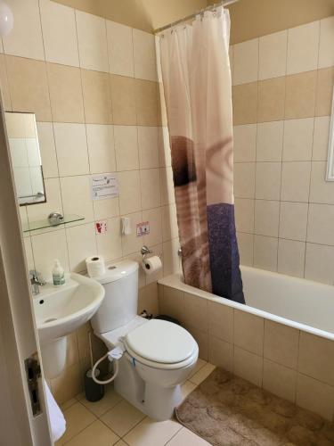 a bathroom with a toilet and a sink and a tub at Villa Joia in Ayia Napa