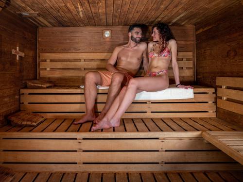 a man and a woman sitting in a sauna at Parc Hotel Germano Suites & Apartments in Bardolino