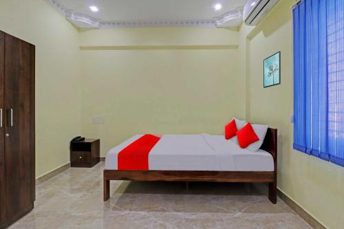 a bedroom with a bed with red pillows on it at Hotel Royal Comfort Near Cubbon Park in Bangalore