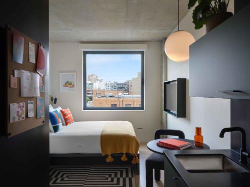 une chambre d'hôtel avec un lit et une fenêtre dans l'établissement Penny Williamsburg, à Brooklyn