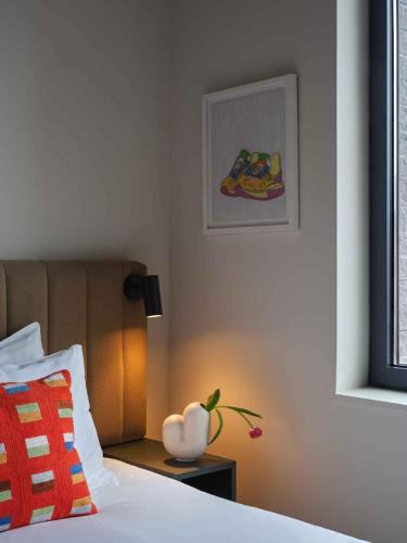 a bedroom with a bed and a vase on a night stand at Penny Williamsburg in Brooklyn