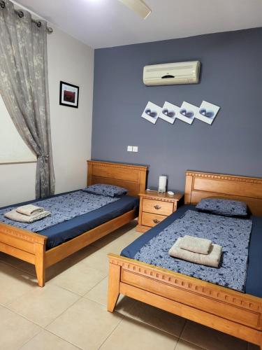 two beds in a room with blue walls at Villa Joia in Ayia Napa