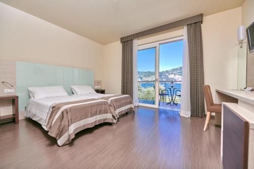 a bedroom with a bed and a view of the ocean at Hotel Campagnola in Malcesine