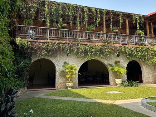 a building with ivy growing on the side of it at Hotel del Patio in Flores