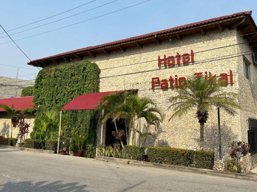 a building with a hotel with a red sign on it at Hotel del Patio in Flores