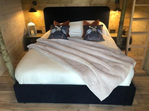 een bed met een witte deken en kussens bij Old Oak Farm in Oakham