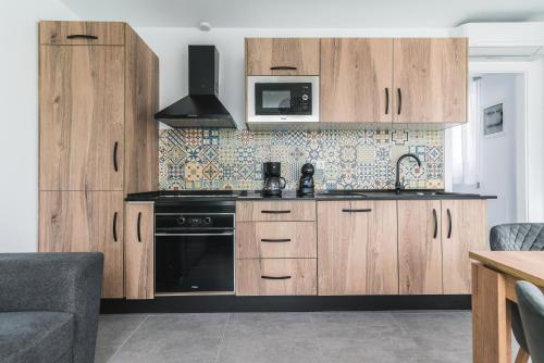 a kitchen with wooden cabinets and a microwave at Open Sea Suites in Las Palmas de Gran Canaria