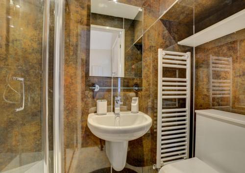 een badkamer met een wastafel, een douche en een toilet bij TLasses Cottage in Kildwick
