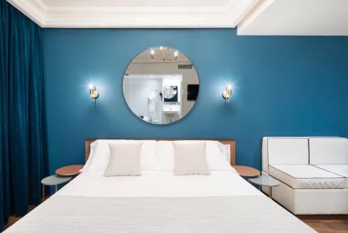 Dormitorio azul con cama y espejo en H Regas Adults Only, en Barcelona