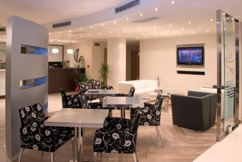 ein Restaurant mit Tischen und Stühlen und einem TV in der Unterkunft Hotel Campagnola in Malcesine