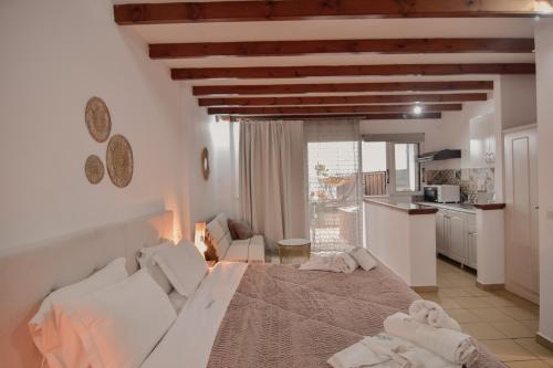 a bedroom with a large bed and a kitchen at Tango Studios in Paleokastritsa