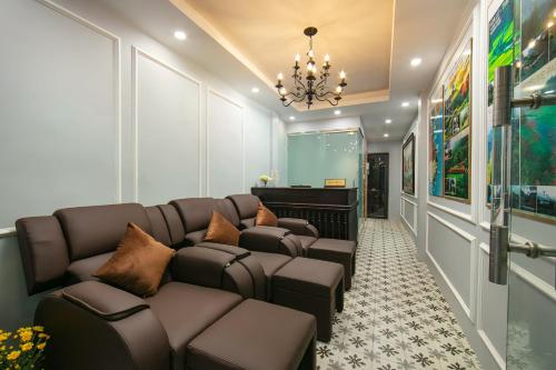 sala de estar con sofá y lámpara de araña en La Renta Hotel & Spa en Hanoi