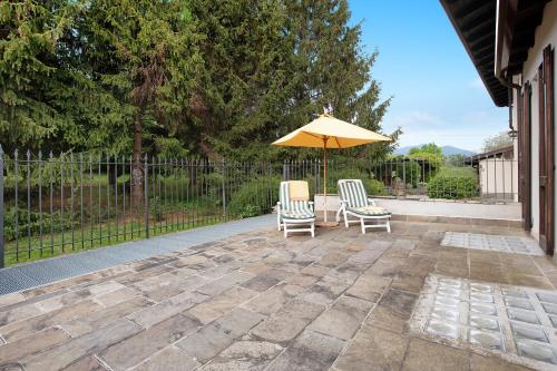 two chairs and an umbrella on a patio at Cascina Nonna Nina in Credaro