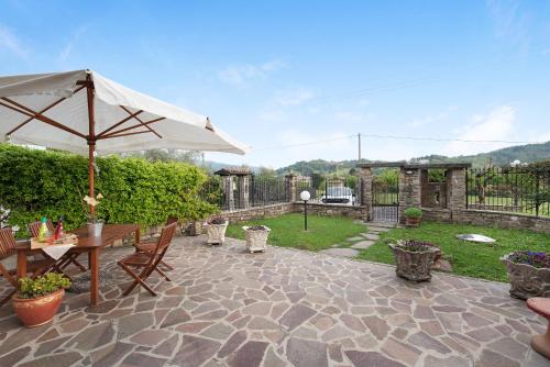 a patio with an umbrella and a table and chairs at Cascina Nonna Nina in Credaro