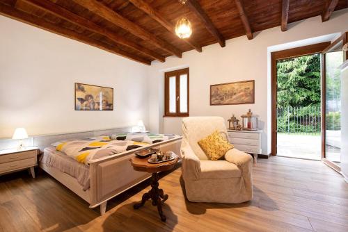 a bedroom with a bed and a chair at Cascina Nonna Nina in Credaro