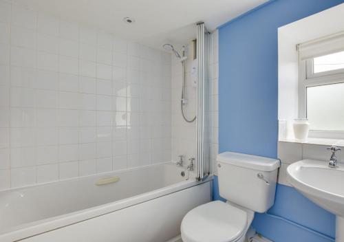 a white bathroom with a toilet and a sink at Thornsgill Cottage in Askrigg