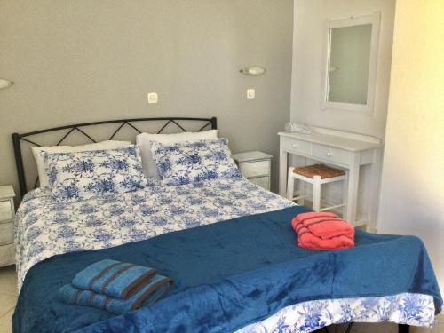 a bedroom with a bed with blue and white sheets at Palm Tree Villa in Almyrida