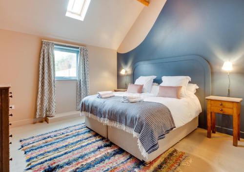 a bedroom with a large bed with a blue wall at The Stables at The Foldyard in Holme upon Spalding Moor