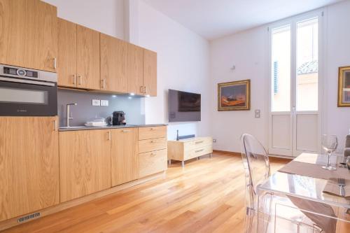a large kitchen with wooden cabinets and a dining table at D'Azeglio & Galluzzi Suites in Bologna
