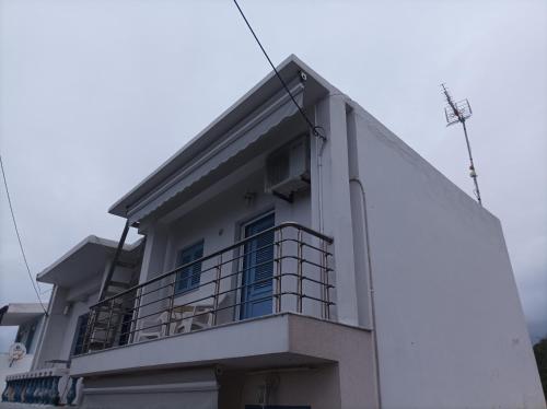 a white building with a balcony on top of it at Remezzo in Mochlos