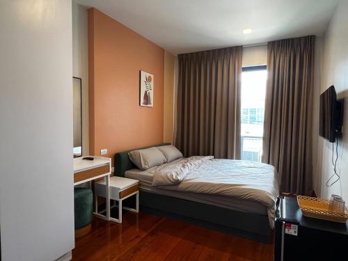um quarto com uma cama, uma secretária e uma janela em Smile Residence at Kaset-Sena em Ban Yang