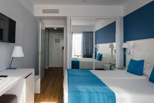 a hotel room with a large bed with blue accents at Alexandre Grand Teguise Playa in Costa Teguise