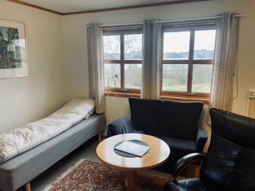sala de estar con sofá, sillas y mesa en Nye Heimen Overnatting, en Namsos