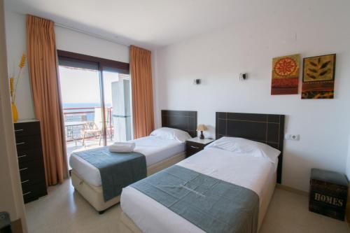 a hotel room with two beds and a balcony at TORREMAR 17-E Levante Beach in Benidorm