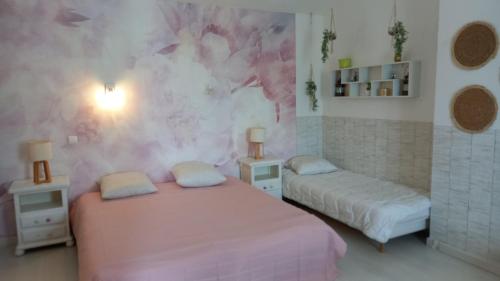 1 dormitorio con 2 camas y pared de color rosa en Les jardins de VIX, en Vix