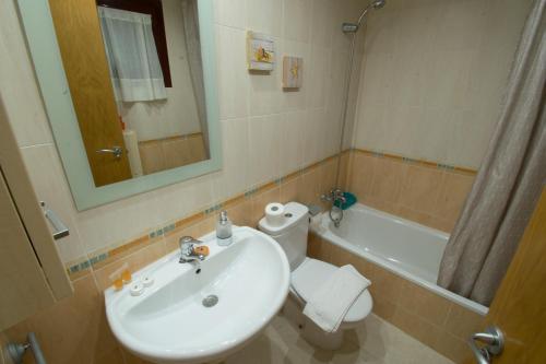 a bathroom with a sink and a toilet and a mirror at TORREMAR 17-E Levante Beach in Benidorm
