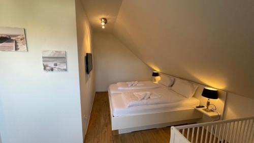 una piccola camera da letto con un letto in mansarda di 'Strandhafer' a Langeoog