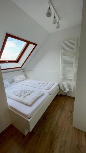 1 dormitorio con 1 cama grande y ventana en 'Strandhafer', en Langeoog