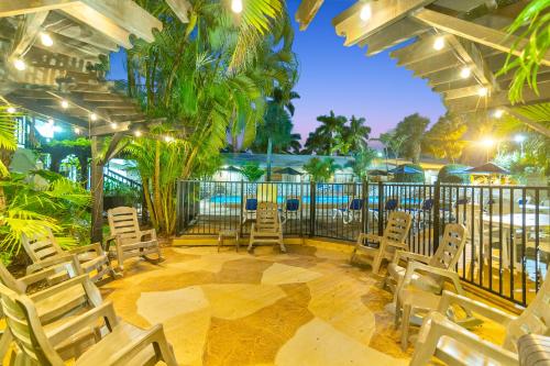 a patio with chairs and a fence and a pool at The Fairways Inn of Naples in Naples