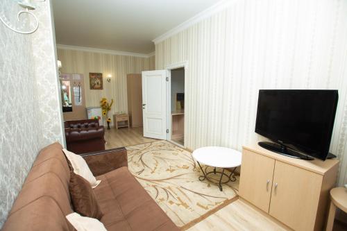 a living room with a couch and a flat screen tv at Aruna Hotel in Astana