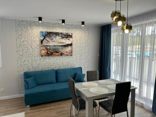 ein Wohnzimmer mit einem blauen Sofa und einem Tisch in der Unterkunft Stegna Apart in Stegna