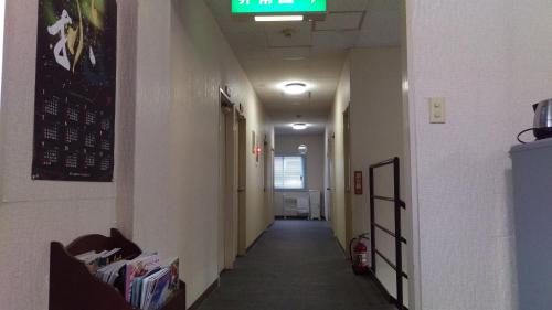 a hallway in a hospital with a sign on the ceiling at ライダーハウス　レッドSUN in Shimonoseki