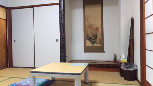 下関市にあるライダーハウス　レッドSUNの白いテーブルと鏡が備わる部屋
