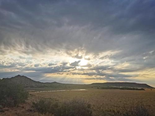 a cloudy sky with the sun in a field at Big Sky Ranch in Colesberg