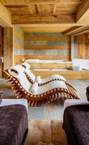 a wooden room with two beds and a couch at Chalet Le Coccole in Sappada